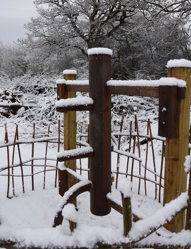 Dennis Ngo's wooden martial arts training dummy standing in a field covered in winter snow